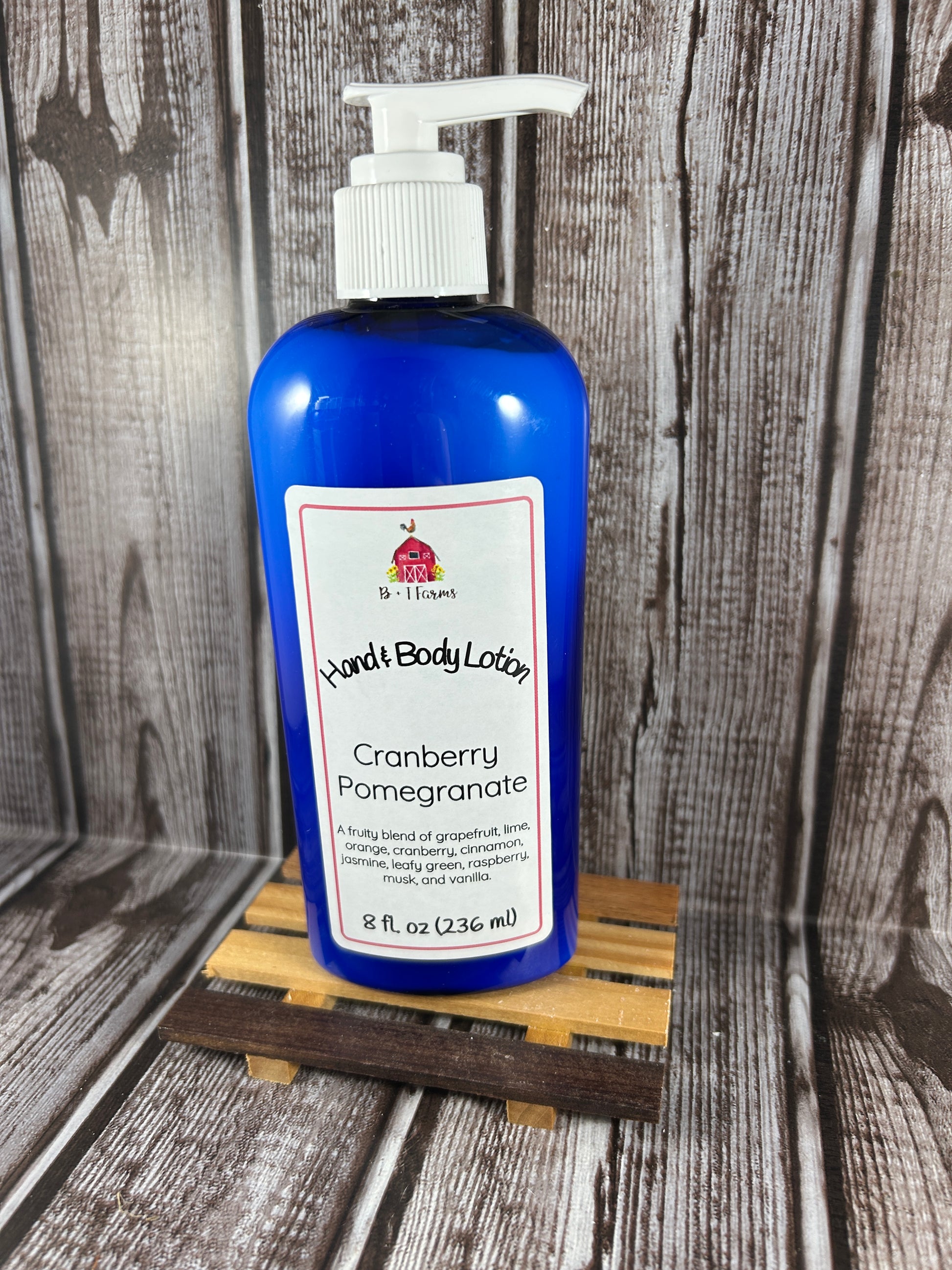 Hand and body lotion bottle on a wooden surface. Scent is called Cranberry Pomegranate