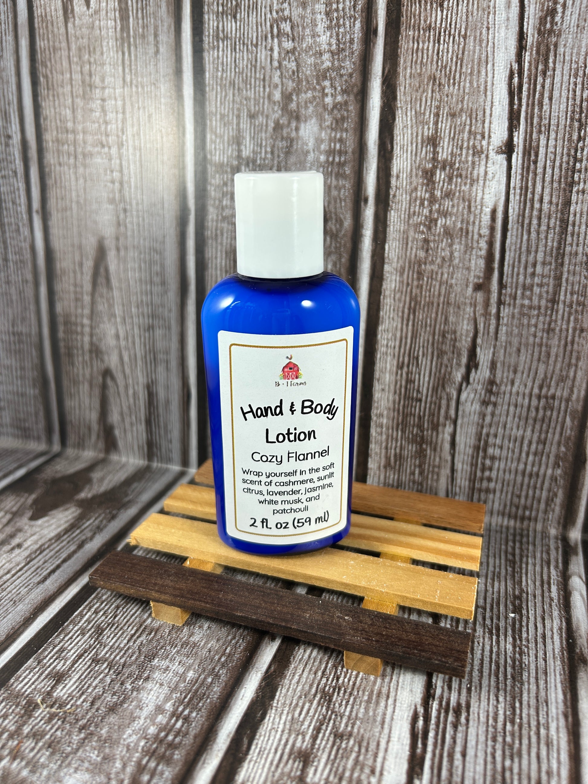 Hand and body lotion bottle on a wooden surface. Scent is called Cozy Flannel