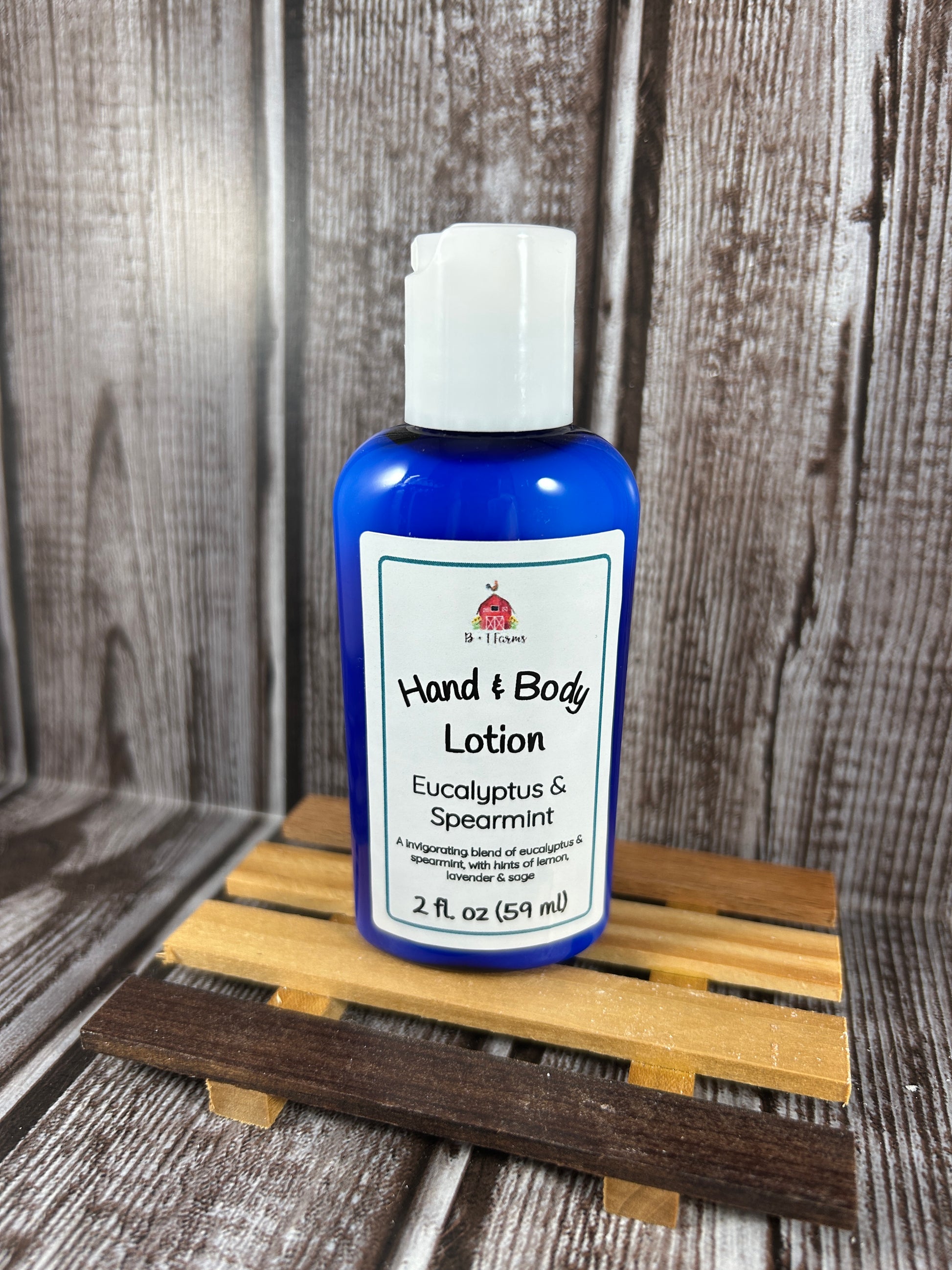 Hand and body lotion bottle on a wooden surface. Scent is called Eucalyptus & Spearmint