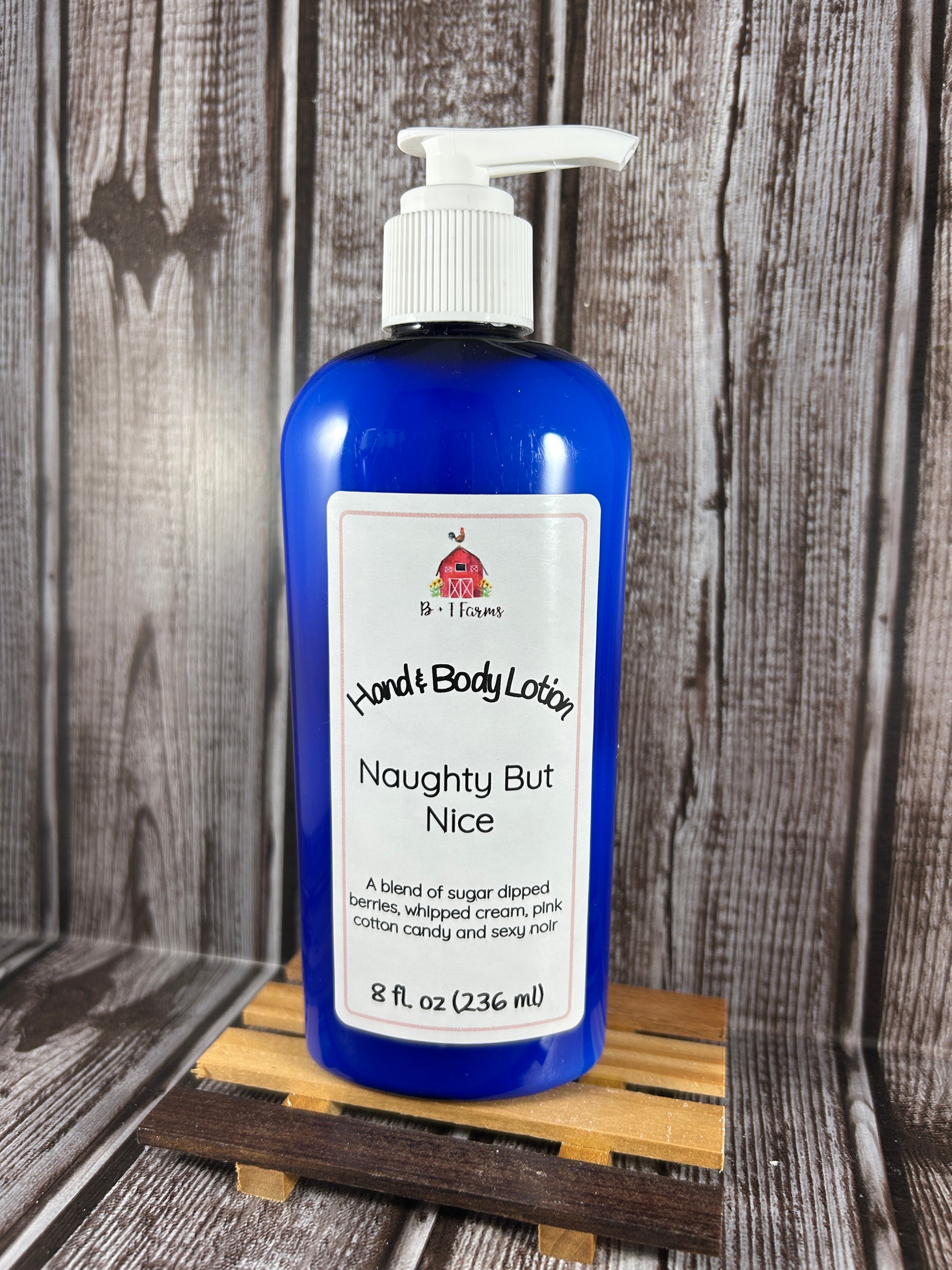Hand and body lotion bottle on a wooden surface. Scent is called Naughty But Nice.