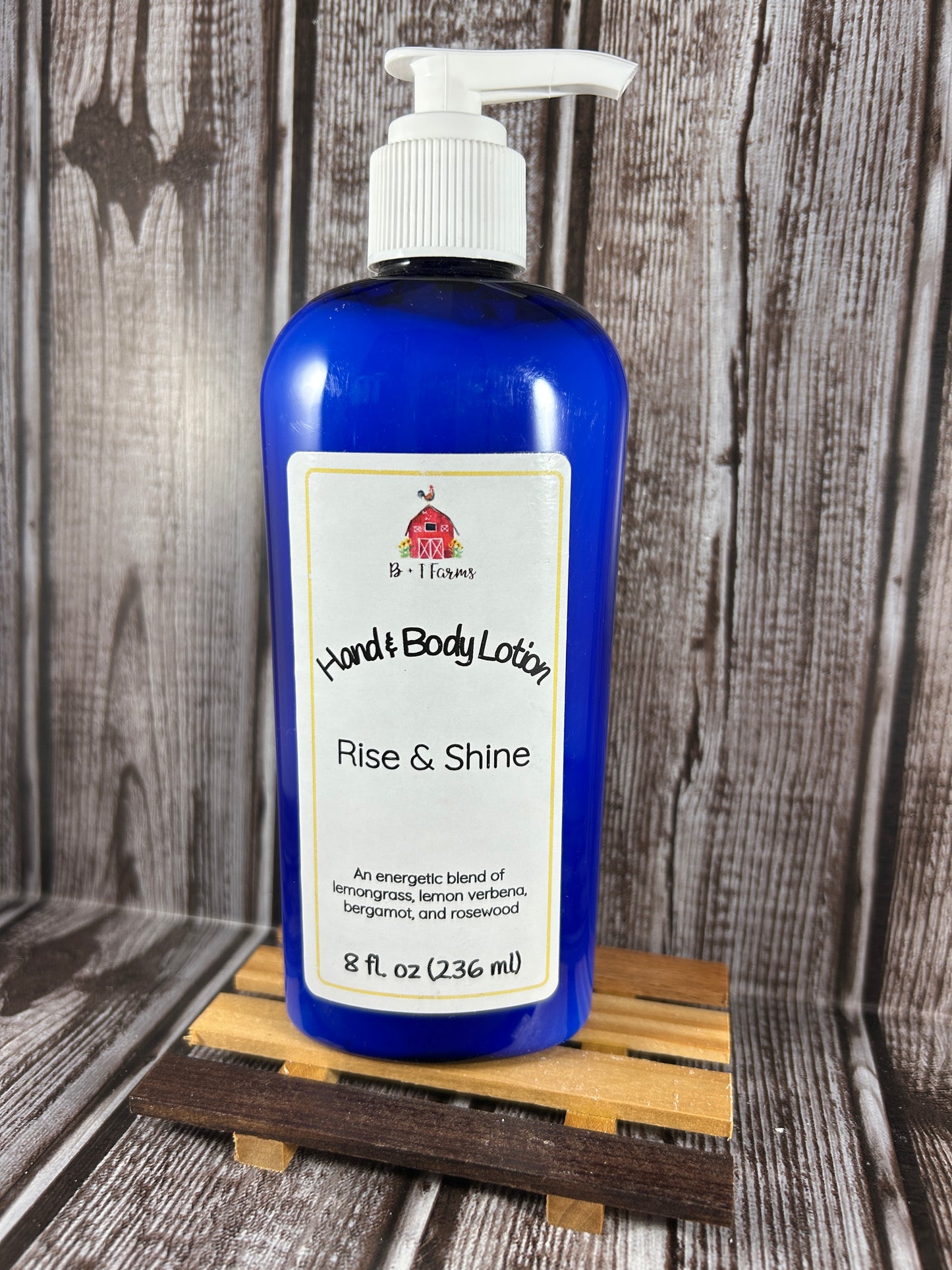 Hand and body lotion bottle on a wooden surface. Scent is called Rise & Shine