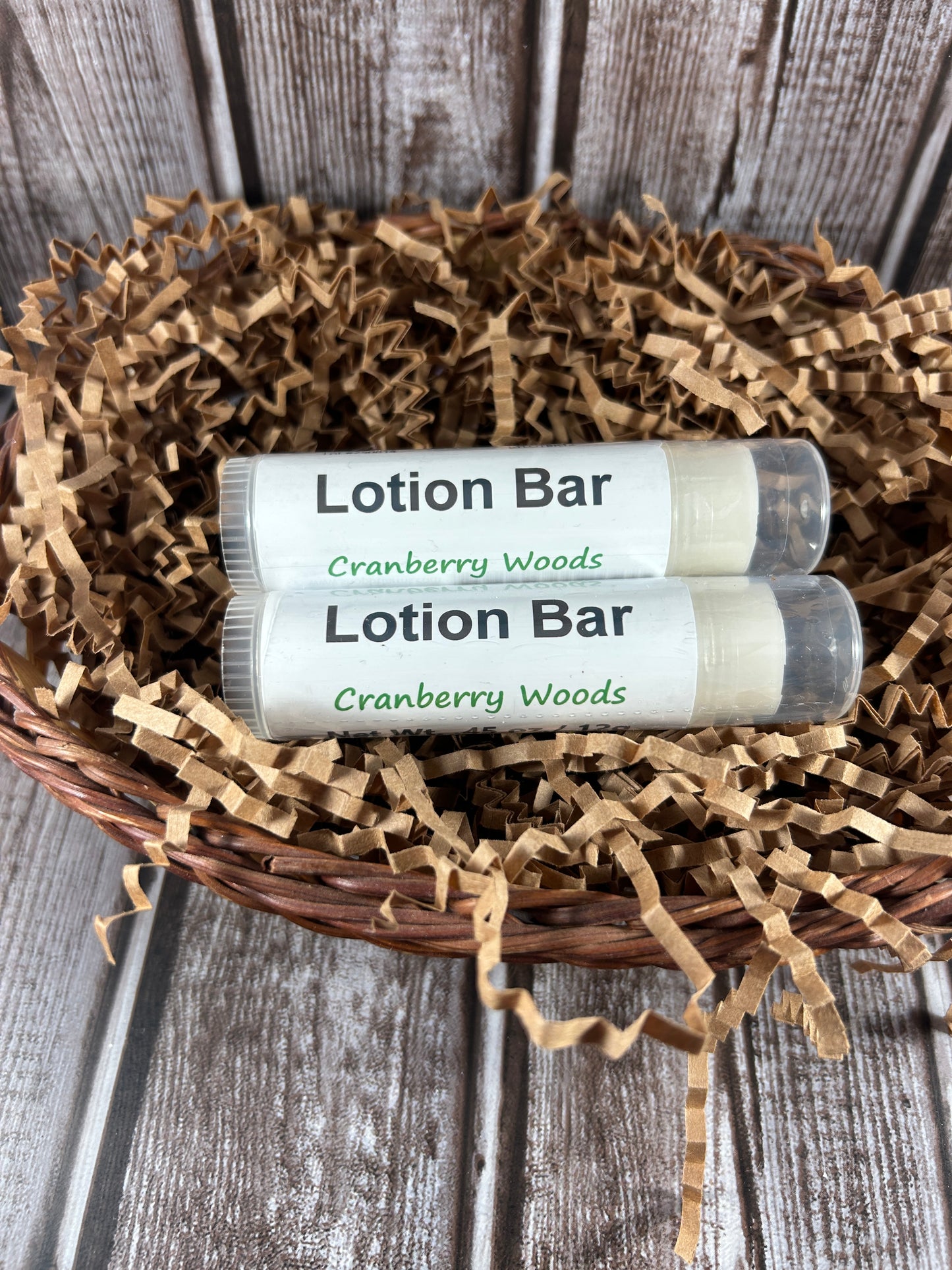 Two lotion bars in a decorative basket on a wooden surface