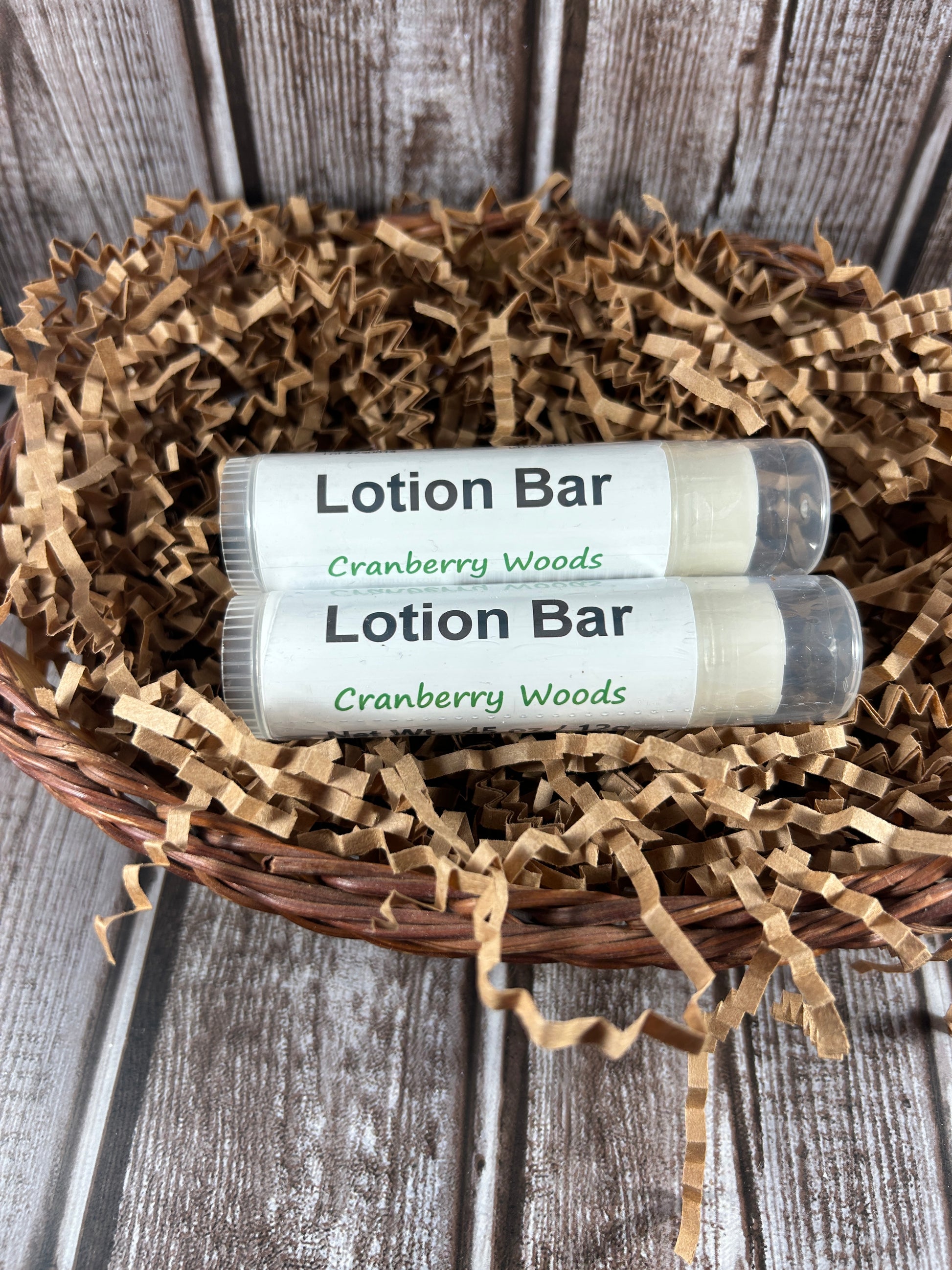 Two lotion bars in a decorative basket on a wooden surface